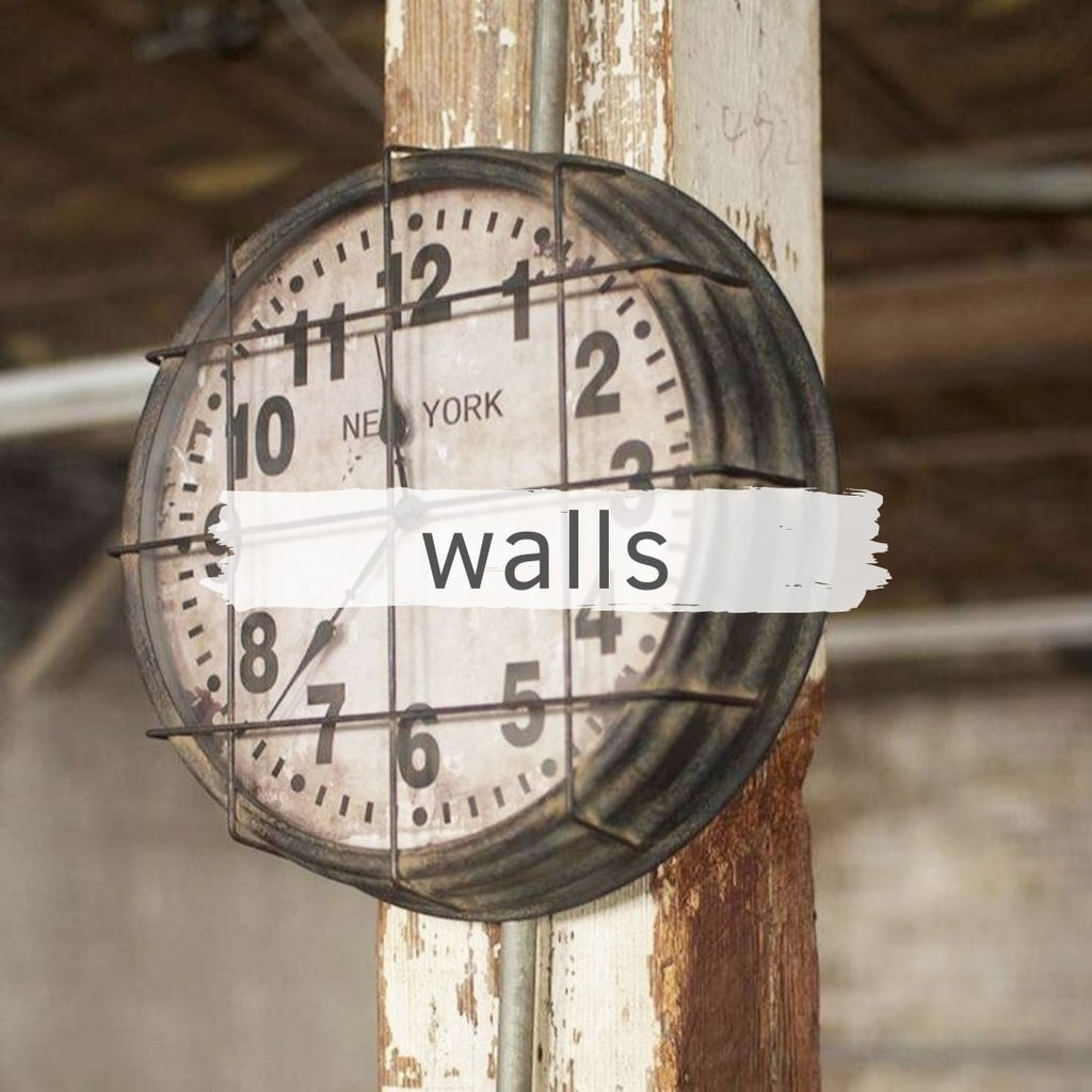 caged vintage style school clock hanging on distressed post in a warehouse