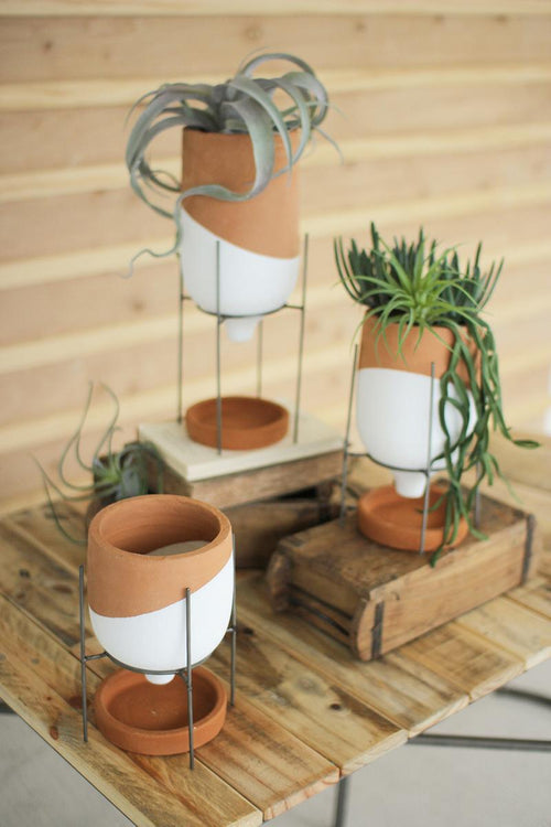 SET OF THREE NATURAL AND WHITE CLAY POTS ON WIRE STANDS
